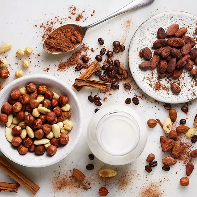 Close-up of nut mix in a bowl with cocoa-covered coffee beans, highlighting quality ingredients