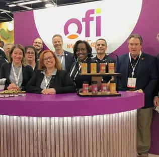 Picture of ofi employees in front of an ofi stand