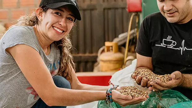 Smiling woman in Peru, holding dried seeds in her hands