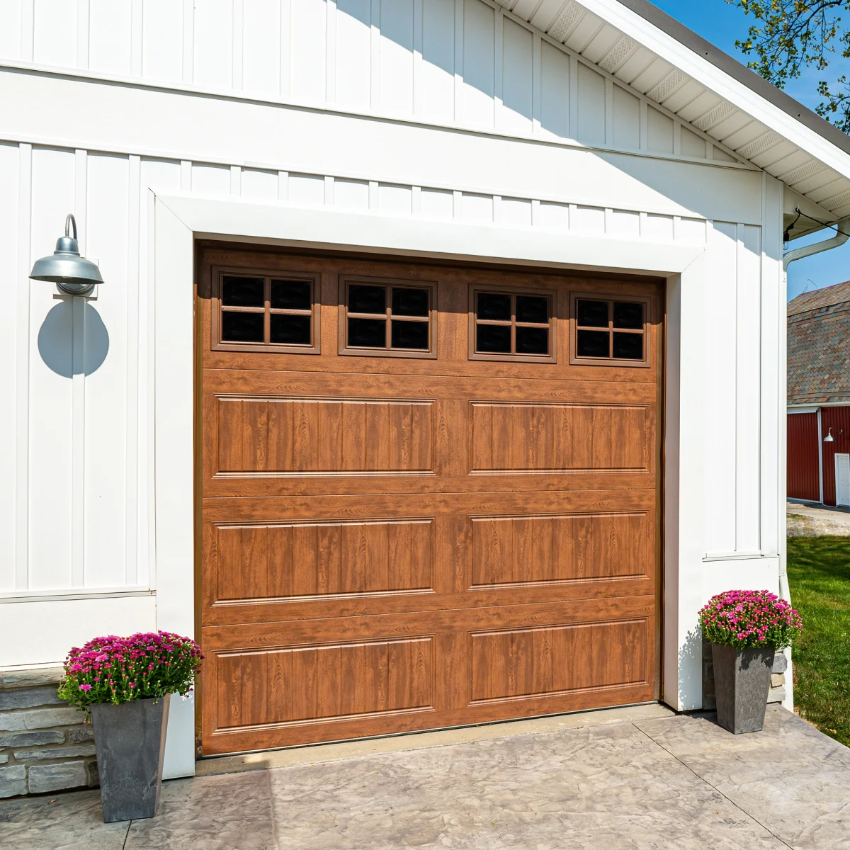 A white house with a wood look rustic garage door