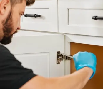 a man tightening cabinet hardware; orange wrench icon