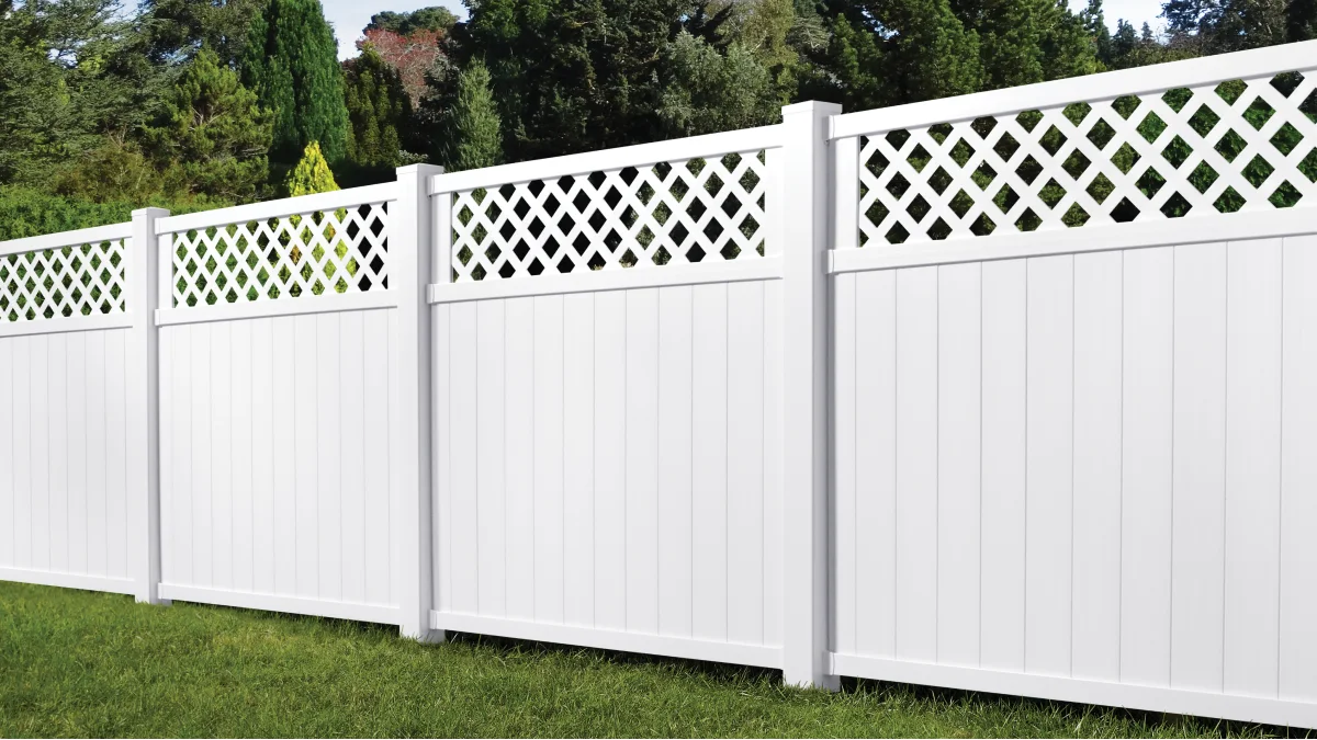 Tall white fence surrounding lush greenery