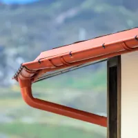 Orange gutter system on a home; orange house icon