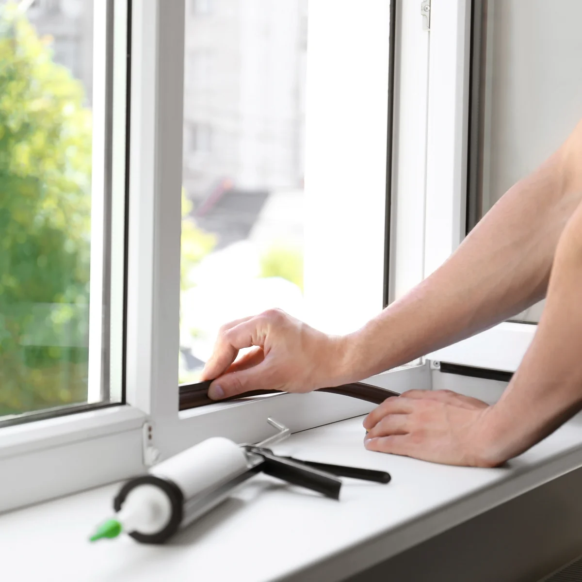 Person sealing their windows