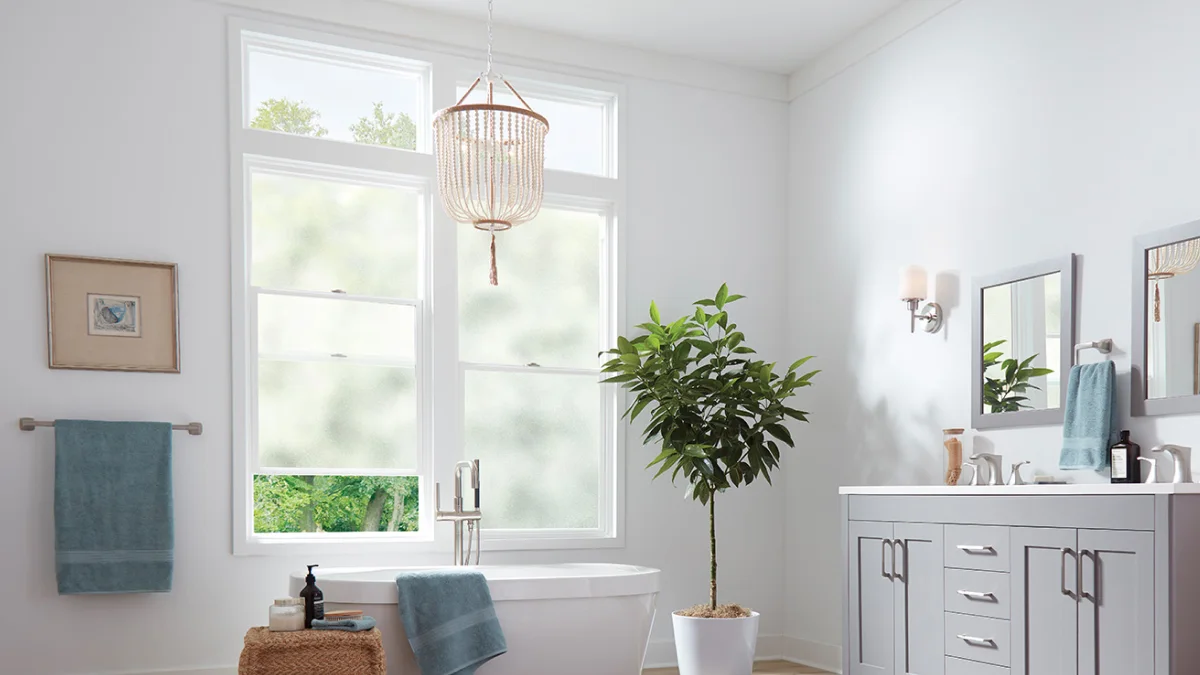 Luxurious modern bathroom with double hung windows with frosted glass