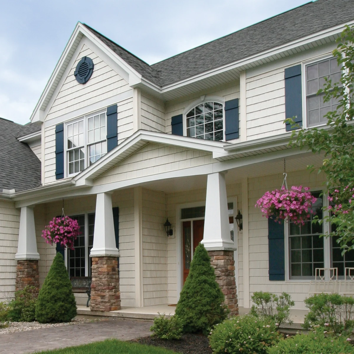 A suburban home with white siding and deep turquoise colonial shutters
