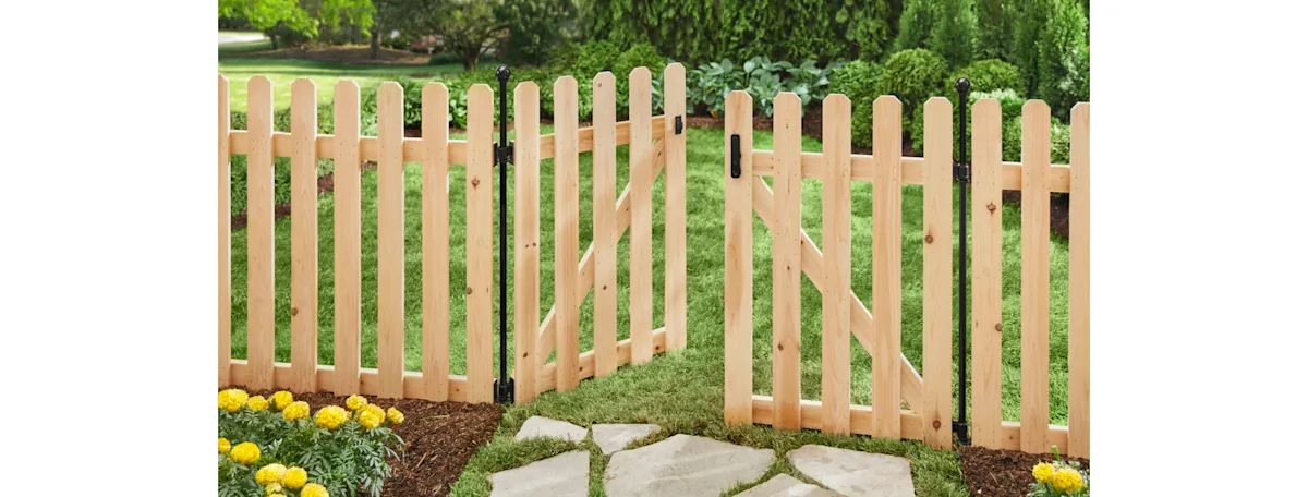 A cedar picket fence with swinging gate