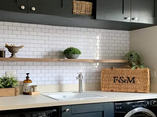 Laundry room with white tile backsplash