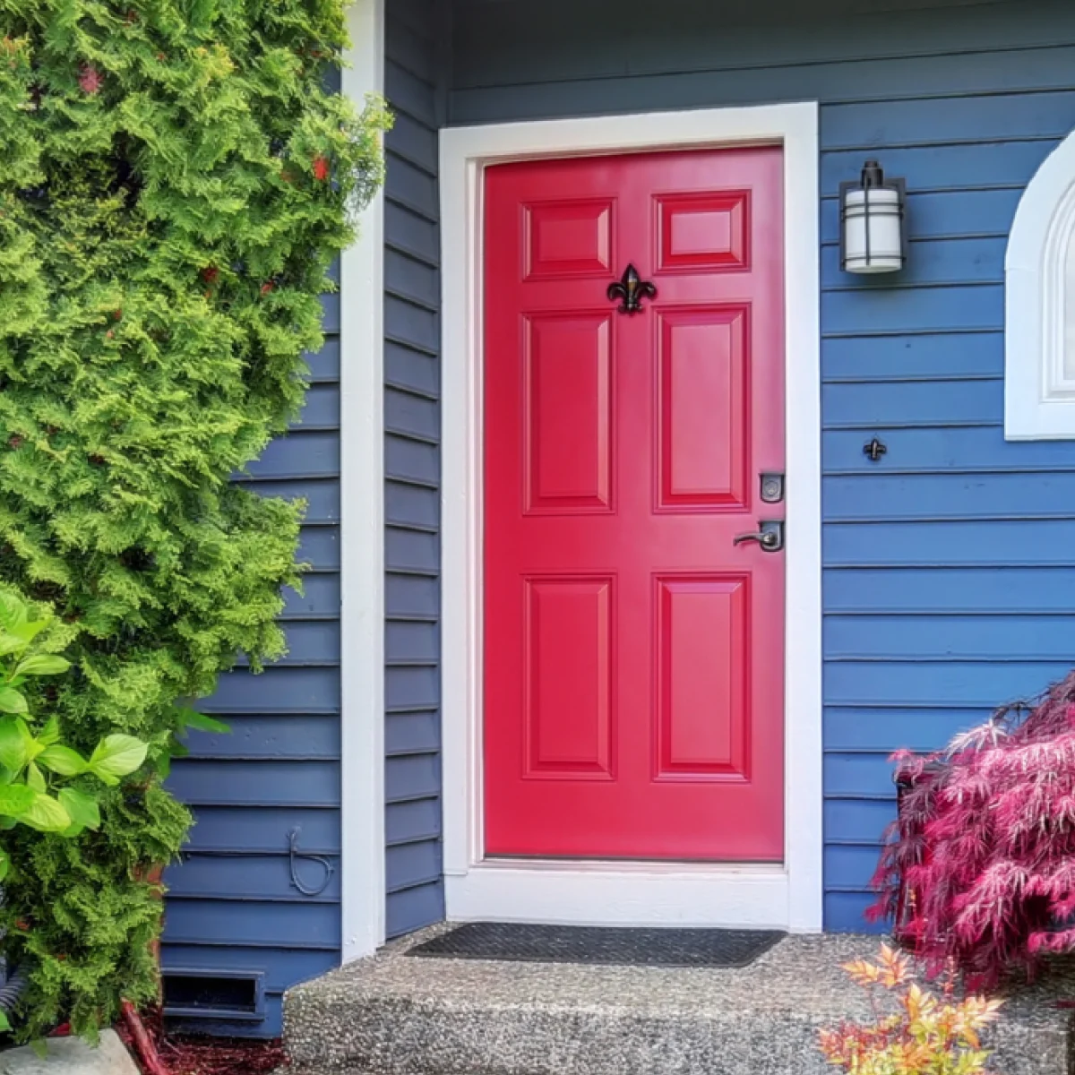 A blue suburban home with a red exterior entry door
