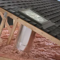 Flat glass sun tunnel skylight with rigid tube and low profile flashing; orange energy saver icon