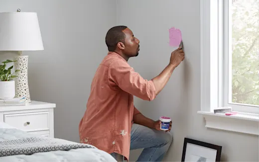 A man patching drywall a window installation.
