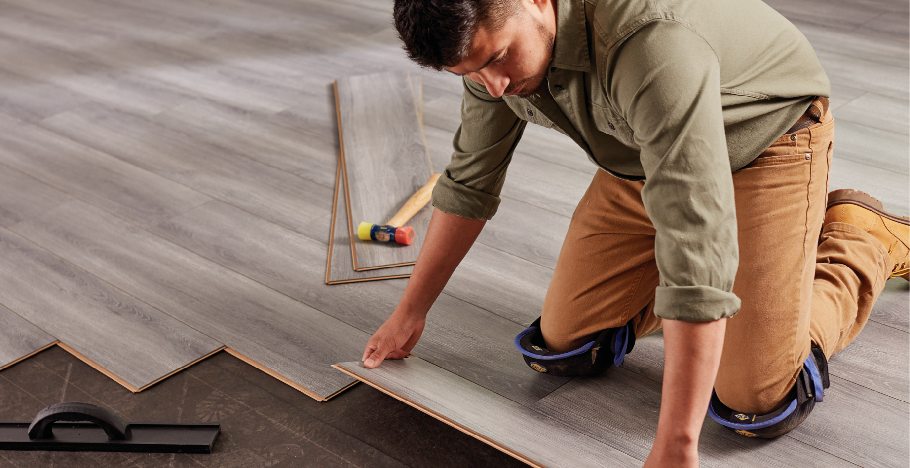 a contractor installing laminate plank flooring