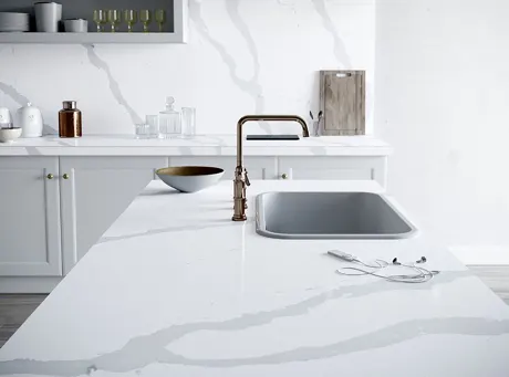 White quartz countertops with a large sink.