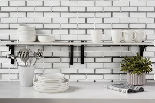 A white glass tile backsplash