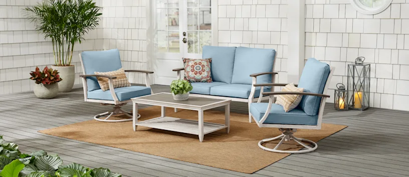 Large outdoor patio with gray wooden deck and blue and white patio furniture