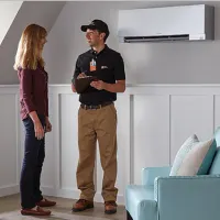 HD Service pro consulting a customer about their recent in-home mini split installation; orange toolbox icon