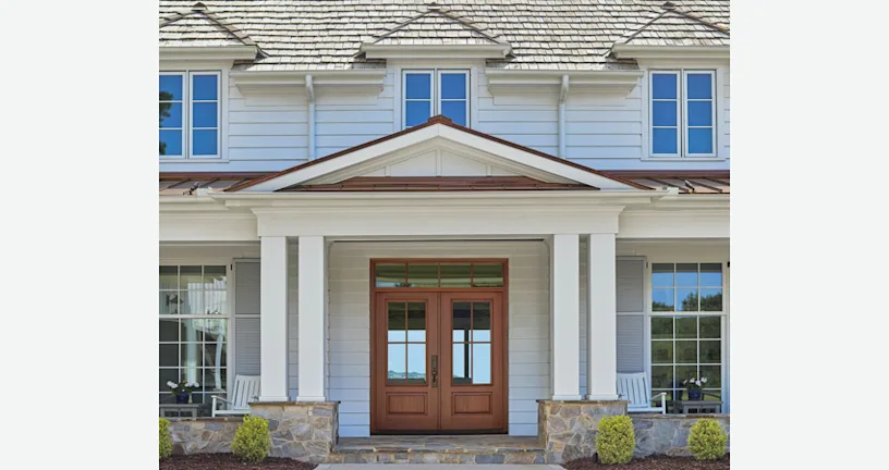 A traditional big white house with a double wood entry door.