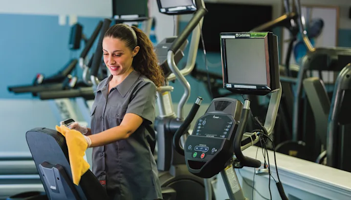 A female janitor cleaning at a gym