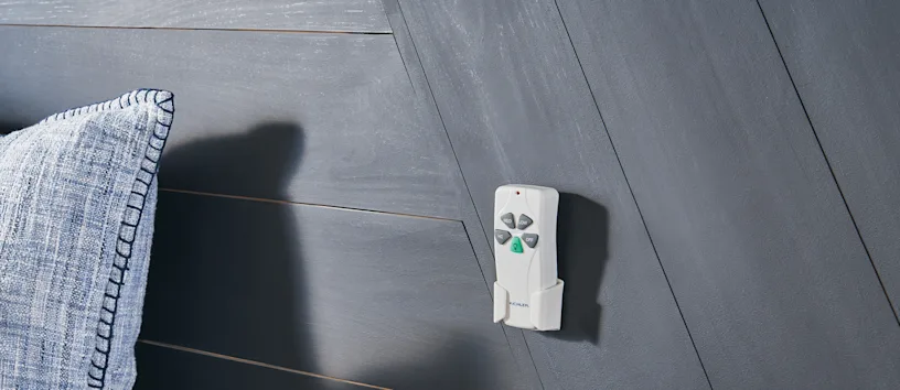 Ceiling fan remote next to bed