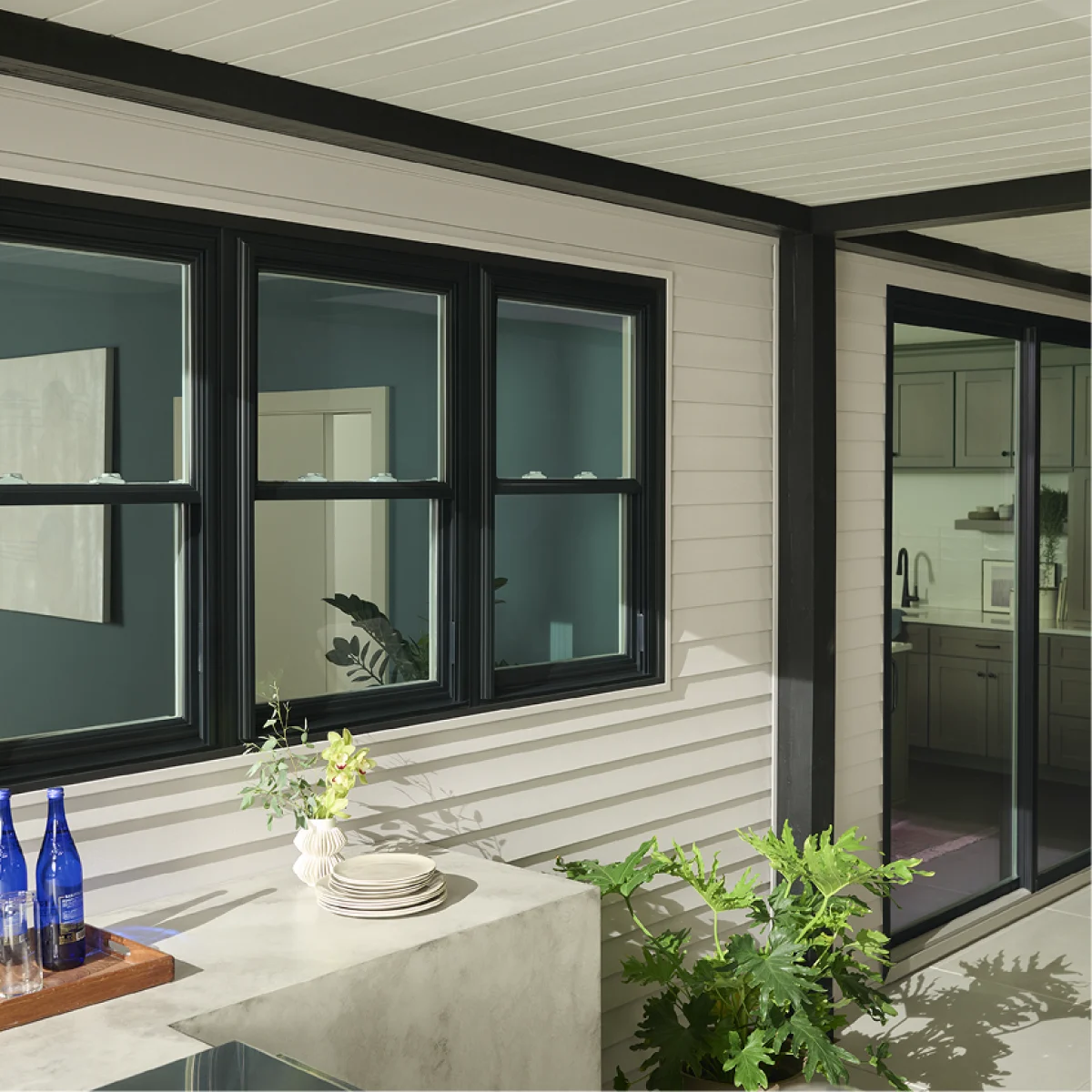 A modern home with black framed windows and a white exterior