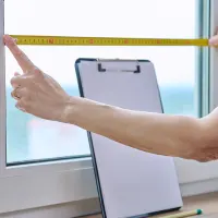 Hands measuring an impact window