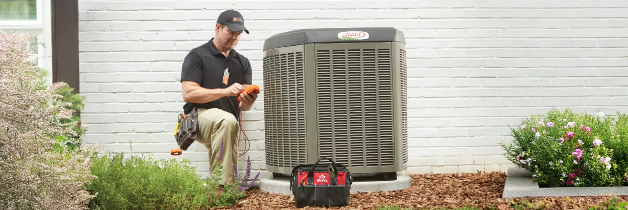 HD Service pro repairing an HVAC unit outside of a customer's home