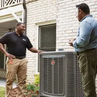 HD Service pro consulting a customer about their HVAC; orange clipboard with check icon