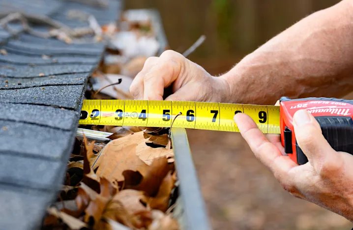 image of a person measuring gutters