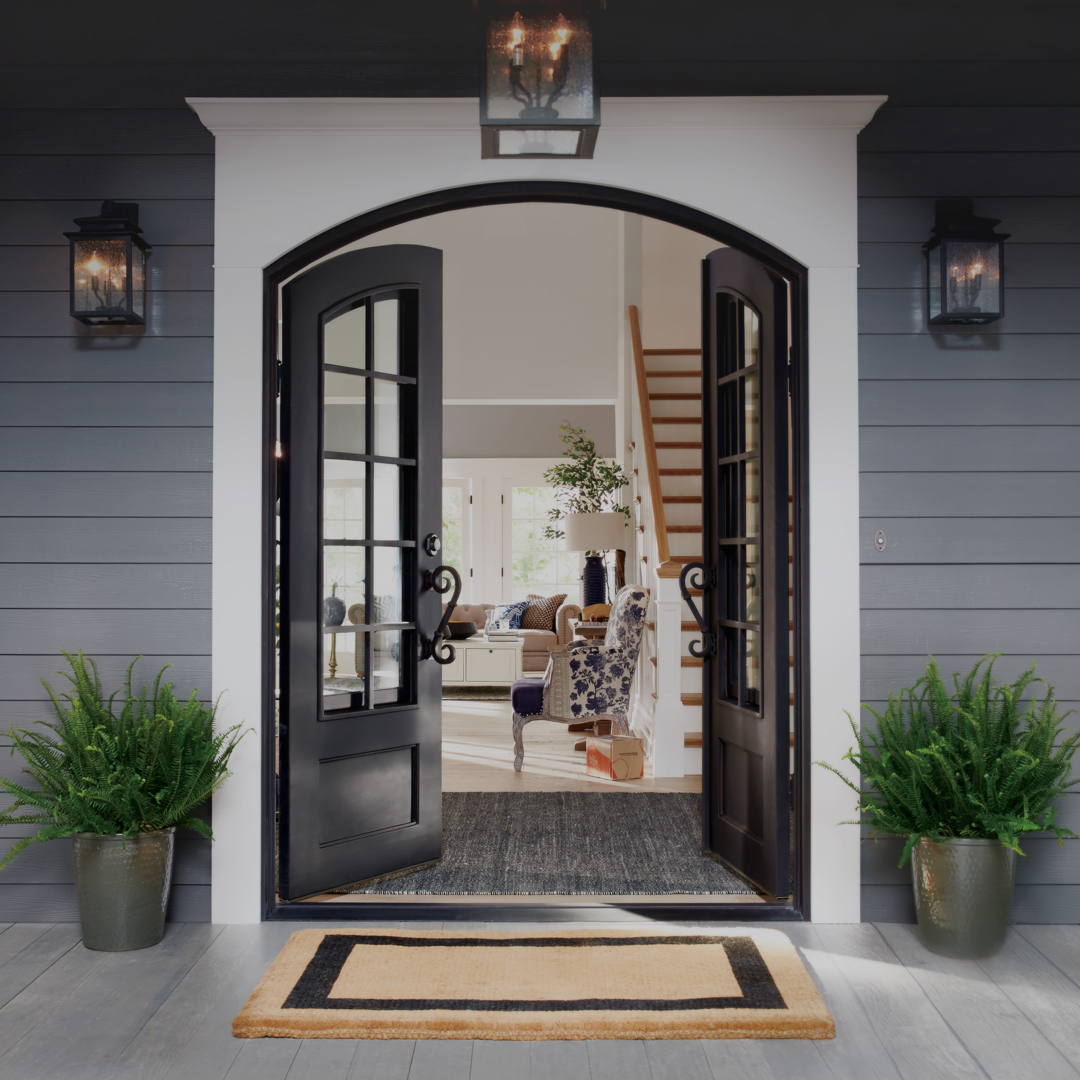 Black front doors with white frame open on grey house 