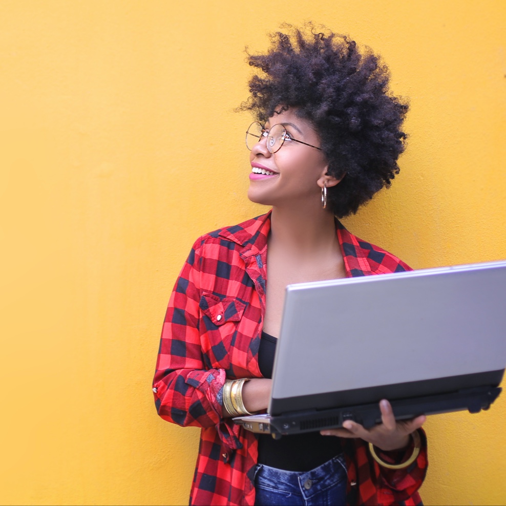 Woman holding a laptop looking up