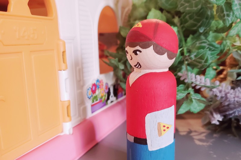 A pizza boy delivering pizza to the door.