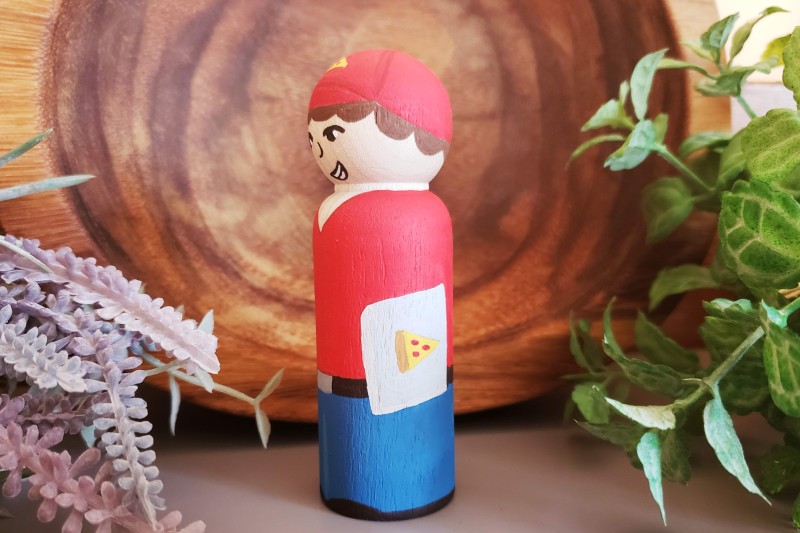 Pizza boy facing side ways with foliage in the background