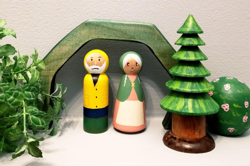 A lighthouse keeper and his wife with foliage in the background.