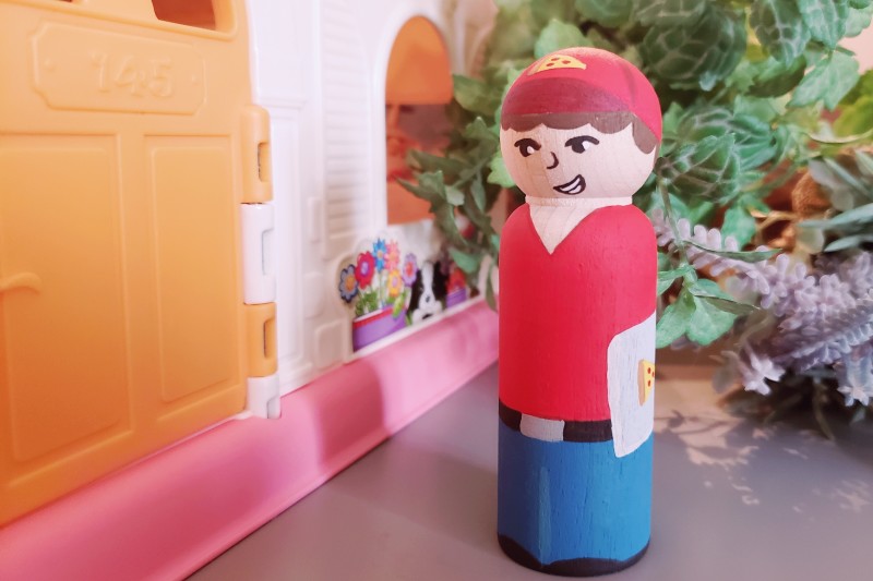 A pizza boy delivering pizza to the front door.