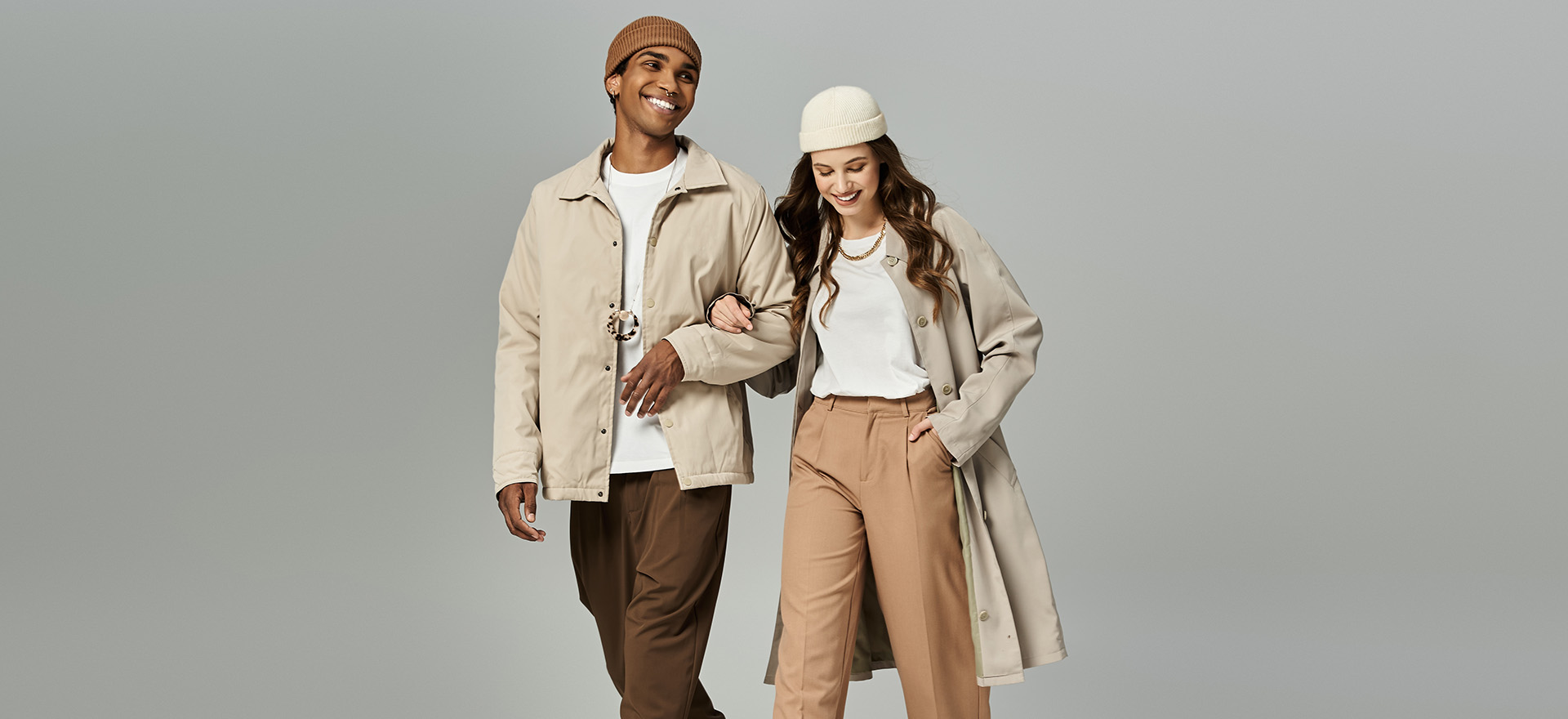 Stylish couple walk hand in hand in autumn clothes