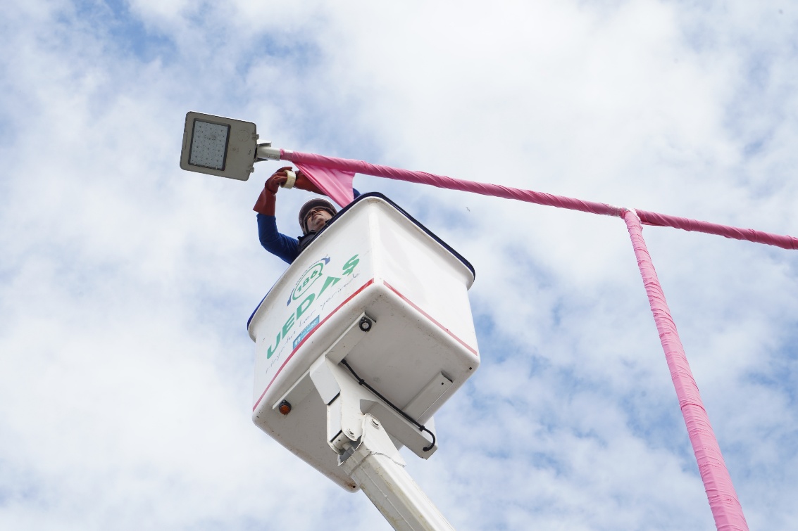 Field teams applying the pink treatment to lighting poles before the campaign month.