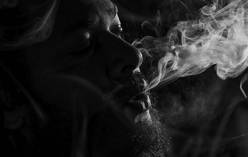 Man blowing smoke out of his mouth