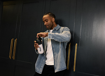 man unscrewing the cap from a Huel shaker
