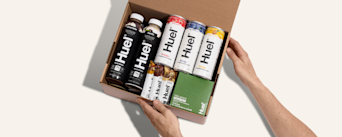 Unboxing a Huel delivery - the brown cardboard box contains multiple Huel powders, protein drinks, and protein snacks