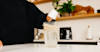 someone adding Huel Powder to water in a blender