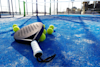Padel racket resting on padel balls on a padel court