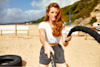 woman with ginger hair and freckles using conditioning ropes on a beach