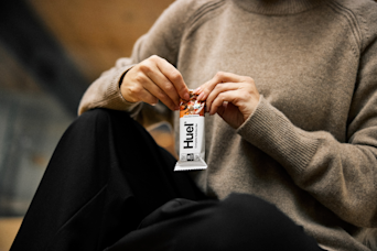 man in a sweater opening a huel complete nutrition bar