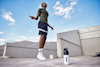 man using a skipping rope outside with a huel shaker on the floor next to him