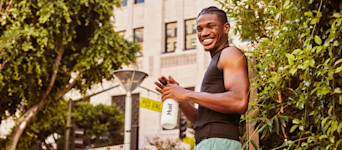 A man smiling holding a huel shaker