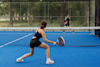 Two people playing padel on a court outside