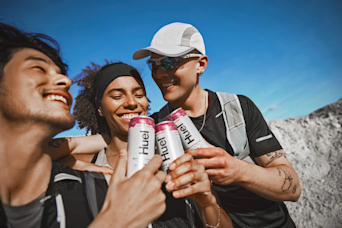 Three people drinking Huel Daily A-Z Vitamin & Minerals energy drinks whilst smiling
