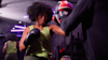 Woman doing boxing training on pads at a gym lit by purple neon lights