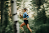 woman running outside with trees blurred in the background