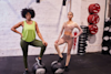 two women stood in gym with a foot on a medicine ball